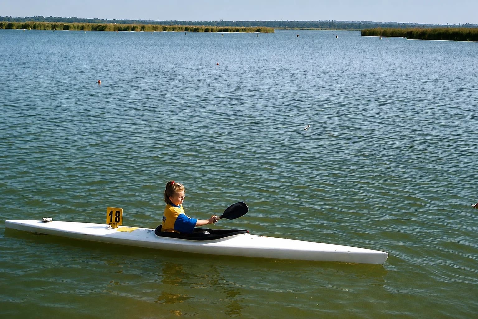 Young athlete paddling a kayak on the water